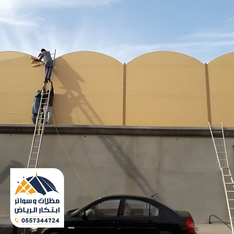 عمال أثناء تركيب ساتر قماش